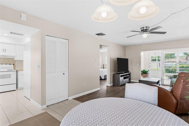 dining room with light tile patterned floors, visible vents, baseboards, and a ceiling fan