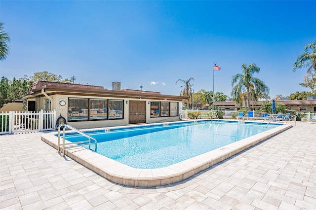 pool with a patio area and fence