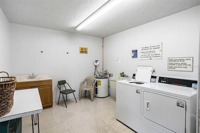 common laundry area featuring electric water heater, baseboards, washing machine and dryer, light floors, and a textured ceiling