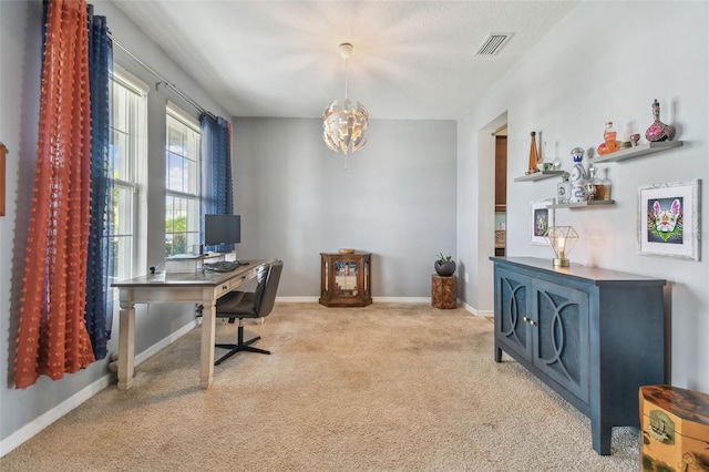 carpeted office featuring a chandelier