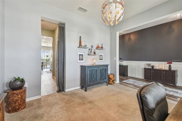 carpeted office with an inviting chandelier