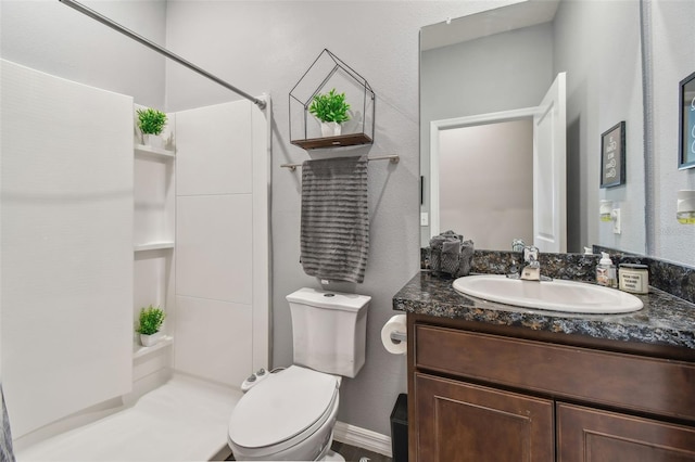 bathroom featuring vanity, toilet, and a shower