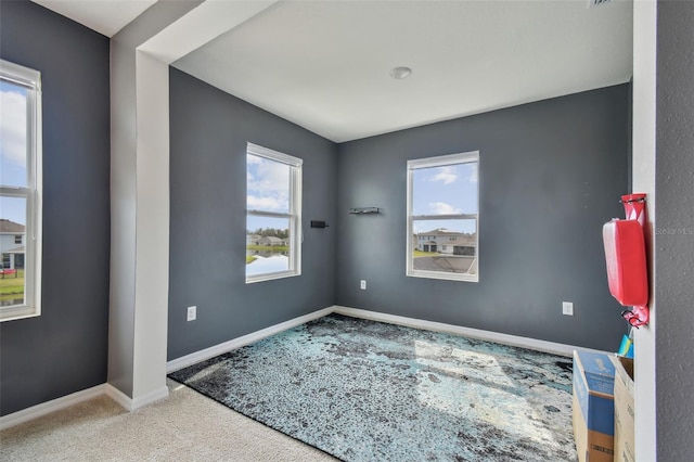 carpeted spare room featuring plenty of natural light