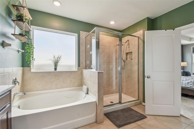 bathroom with tile patterned floors, independent shower and bath, and vanity