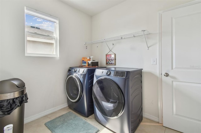 washroom with light tile patterned floors and washer and clothes dryer