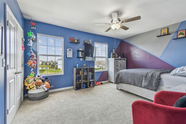 bedroom with multiple windows, ceiling fan, a textured ceiling, and carpet flooring