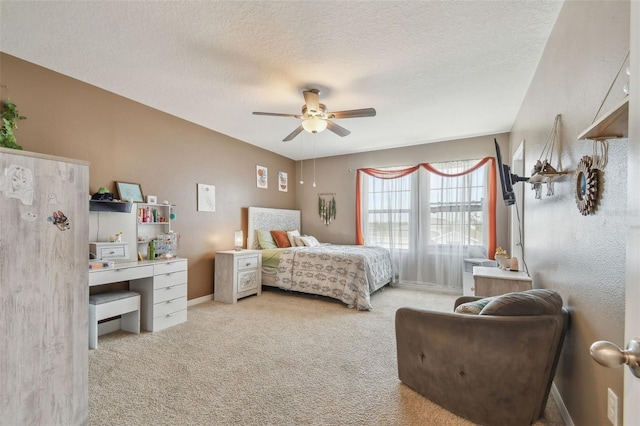 bedroom with ceiling fan, light carpet, and a textured ceiling