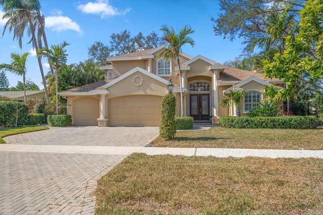 view of front of house with french doors, a garage, and a front yard