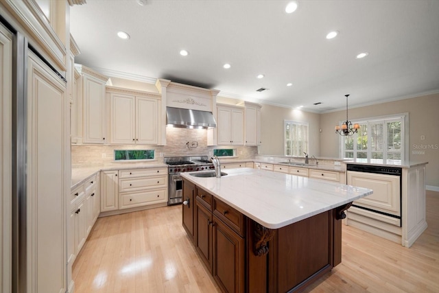 kitchen with sink, extractor fan, double oven range, kitchen peninsula, and pendant lighting