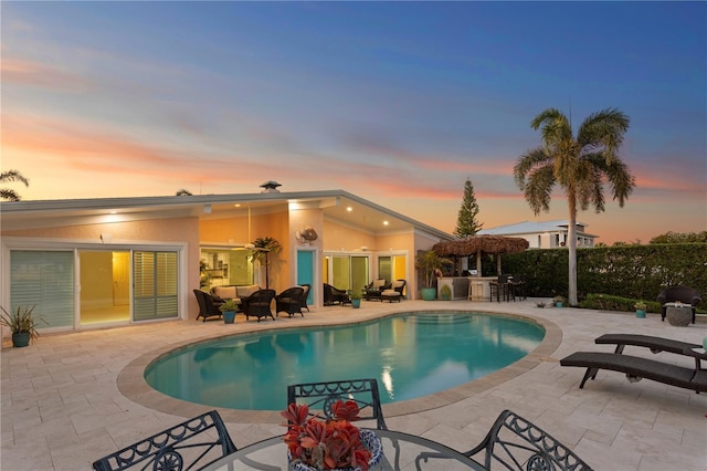 outdoor pool featuring outdoor dry bar and a patio