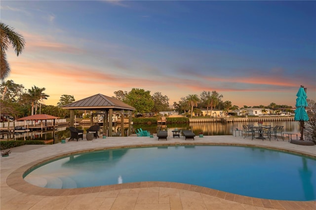 outdoor pool with a water view and a gazebo