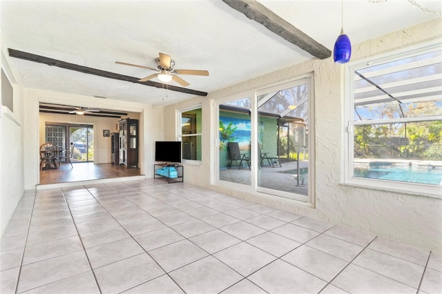 unfurnished living room with light tile patterned floors, ceiling fan, and beam ceiling