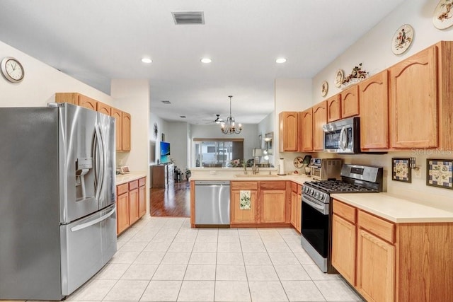 kitchen with sink, light tile patterned floors, kitchen peninsula, pendant lighting, and stainless steel appliances