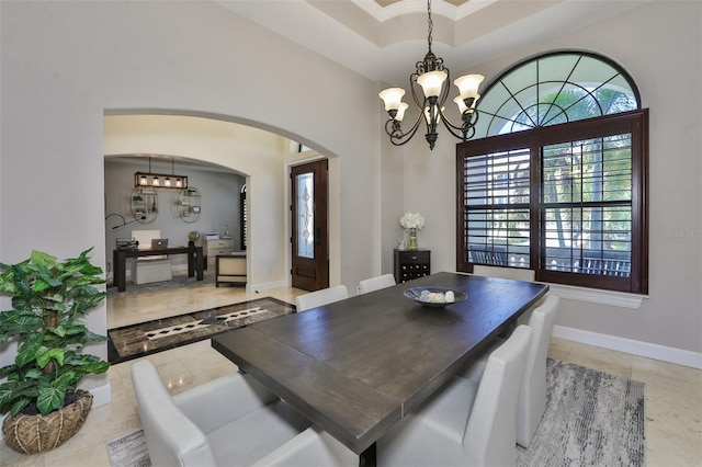dining area with light tile patterned floors, baseboards, arched walkways, and an inviting chandelier