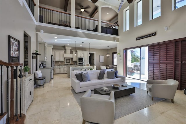 living room featuring a wealth of natural light, light tile patterned floors, a towering ceiling, and a ceiling fan