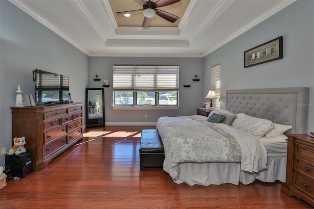 bedroom featuring baseboards, a raised ceiling, ornamental molding, a ceiling fan, and wood finished floors