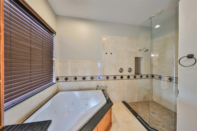 full bath featuring tile patterned flooring, tile walls, tiled shower, and a jetted tub