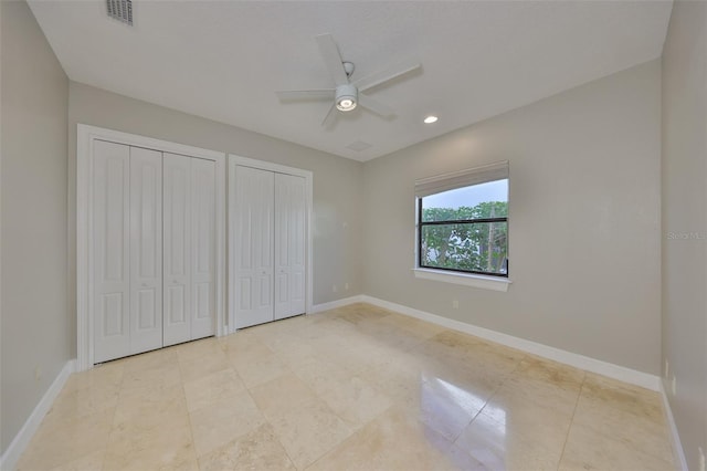 unfurnished bedroom with visible vents, baseboards, two closets, and ceiling fan