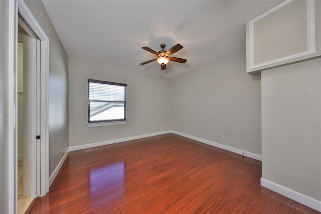 interior space with a textured ceiling, baseboards, a ceiling fan, and wood finished floors