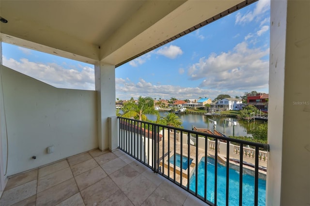 balcony with a water view and a pool with connected hot tub