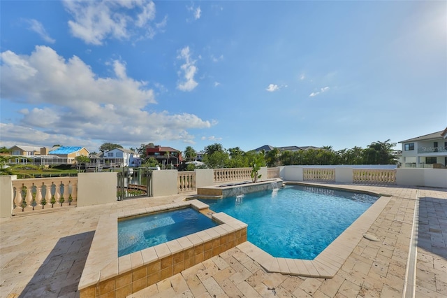 view of swimming pool featuring a patio area, fence, a pool with connected hot tub, and a residential view