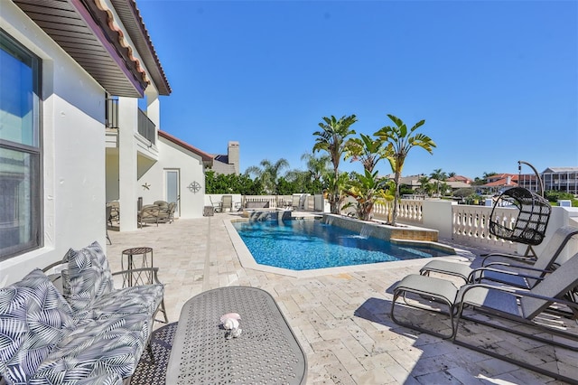 view of pool with a patio area, a pool with connected hot tub, and fence