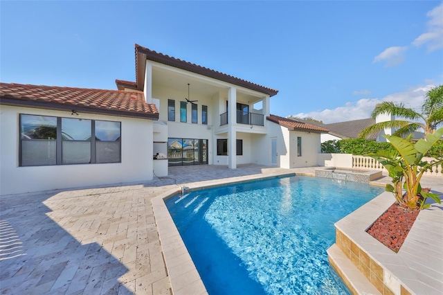 back of house with stucco siding, a ceiling fan, a patio, a tile roof, and a balcony