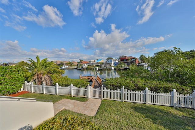 water view with a fenced front yard and a boat dock