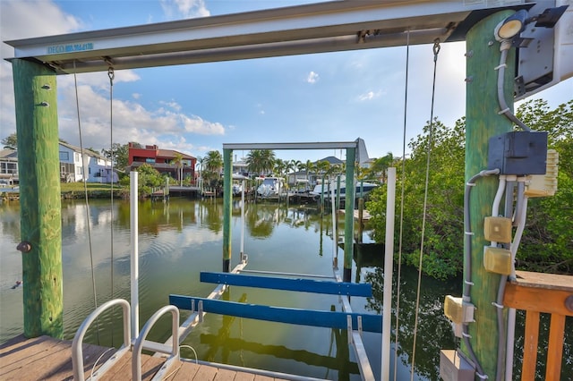 dock area with boat lift and a water view