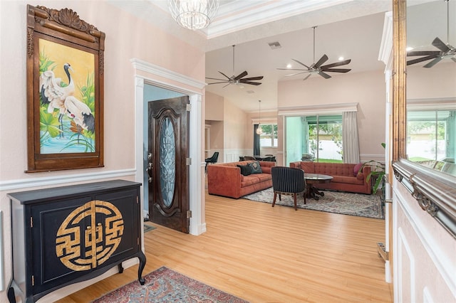 foyer featuring light wood-type flooring, a wealth of natural light, and visible vents