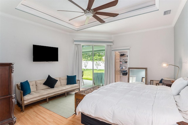 bedroom featuring ornamental molding, access to outside, a tray ceiling, and visible vents