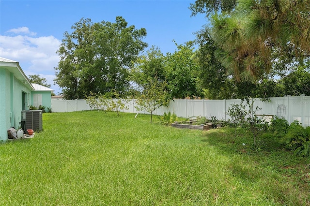 view of yard featuring a garden, cooling unit, and a fenced backyard