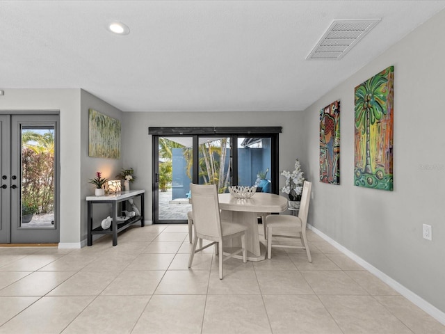 tiled dining room featuring french doors