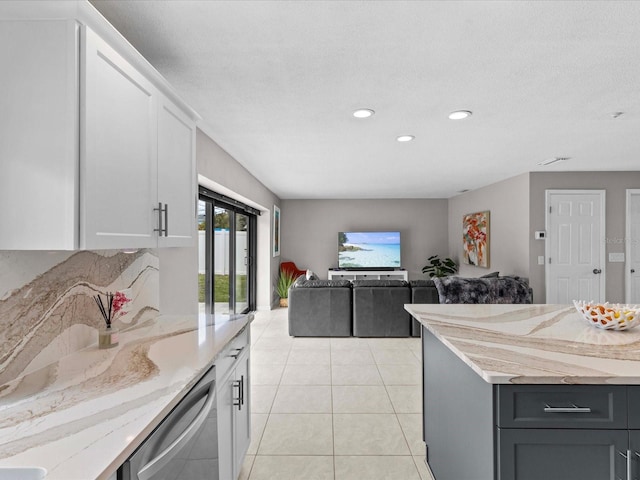 kitchen featuring white cabinetry, dishwasher, light tile patterned floors, light stone countertops, and a textured ceiling