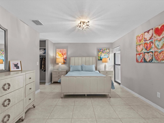 bedroom with light tile patterned floors and a textured ceiling