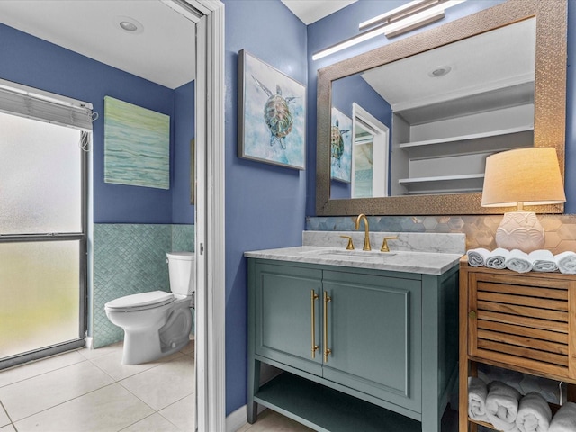 bathroom with tile patterned flooring, vanity, tile walls, and toilet