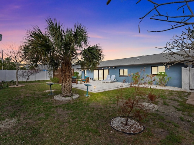 yard at dusk featuring a patio area