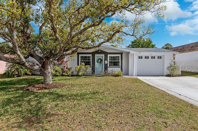 single story home featuring a garage, a front yard, driveway, and stucco siding