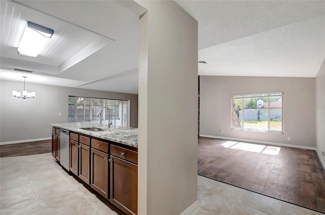 kitchen featuring dark brown cabinetry, sink, light stone counters, vaulted ceiling, and dishwasher