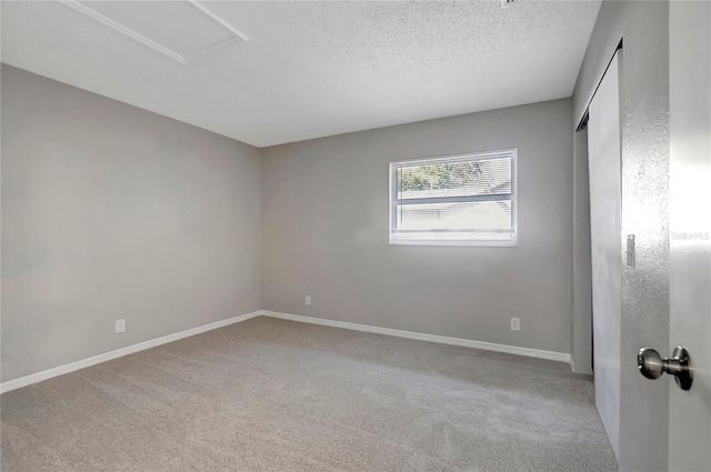 carpeted empty room with a textured ceiling