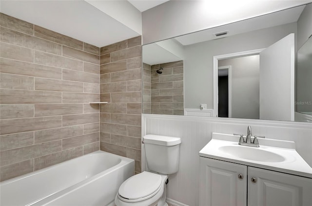 full bathroom featuring vanity, tiled shower / bath combo, and toilet