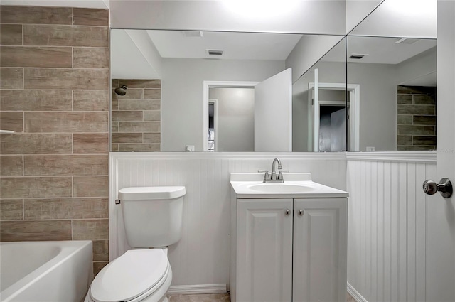 full bathroom with tiled shower / bath combo, vanity, and toilet