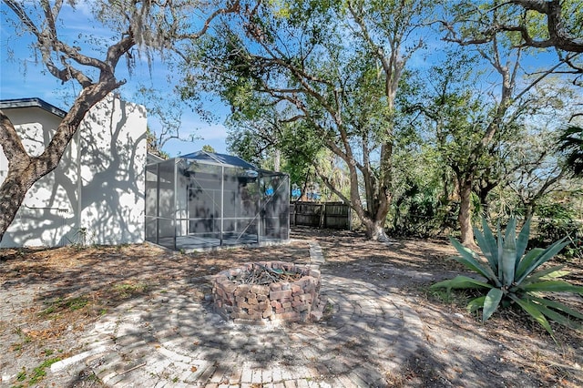 view of yard with a lanai and a fire pit