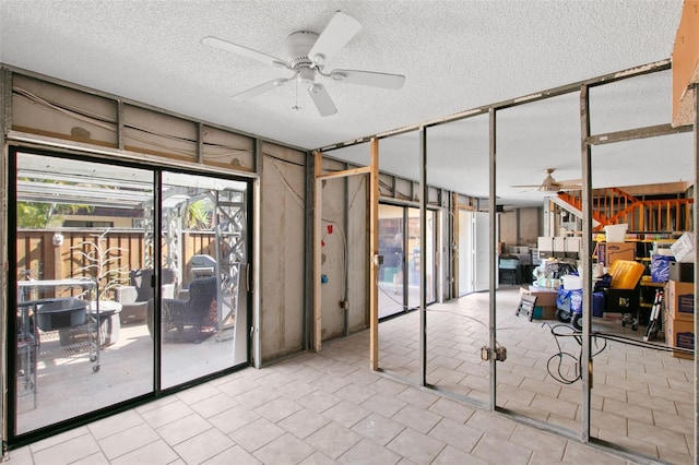 unfurnished room featuring light tile patterned floors, a textured ceiling, ceiling fan, and a wall of windows