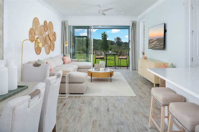 living room with ceiling fan, ornamental molding, and light hardwood / wood-style flooring