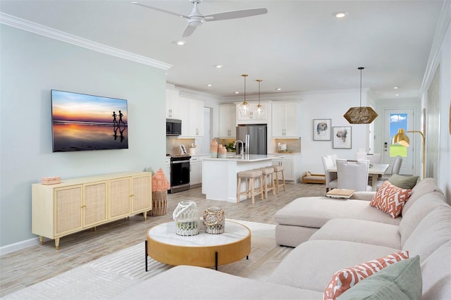 living room featuring ceiling fan, ornamental molding, and light hardwood / wood-style flooring