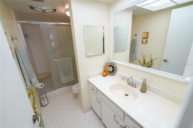 bathroom with a shower with door, vanity, tile patterned flooring, and toilet