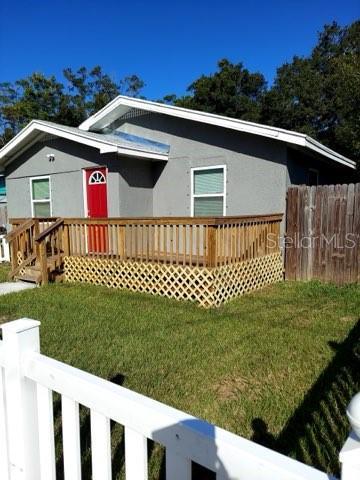 view of front of home with a wooden deck and a front lawn