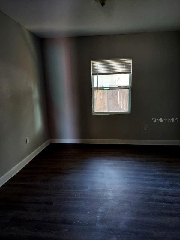 unfurnished room featuring dark wood-type flooring