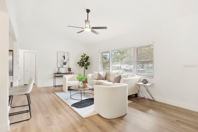 living room with ceiling fan, high vaulted ceiling, and light hardwood / wood-style flooring